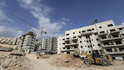 A bulldozer clears rocks at a construction site in a Jewish settlement near Jerusalem known to Israelis as Har Homa and to Palestinians as Jabal Abu Ghneim. Ammar Awad / Reuters