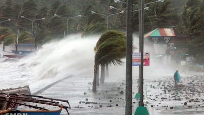A resident walks past high waves pounding the sea wall amidst strong winds as Typhoon Haiyan hit the city of Legaspi, Albay province, south of Manila on November 8, 2013. Charism Sayat / AFP Photo