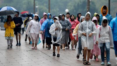 Children wearing ponchos are seen as they walk in rain in Sydney's central business district, New South Wales, Australia. EPA