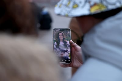 People watch Britain's Catherine, Princess of Wales' announcement about her health, outside Buckingham Palace in London. Reuters