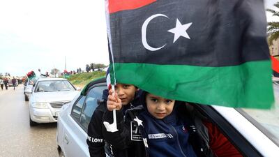 Libyan children wave their national flag in the capital Tripoli during a celebration to mark the upcoming eight anniversary of the Libyan revolution which toppled Muammar Qaddafi. AFP