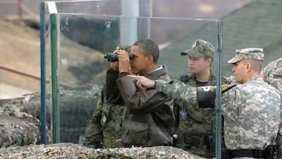 US President Barack Obama looks through binoculars to see North Korea from Observation Post Ouellette in the Demilitarised Zone, the tense military border between the two Koreas.