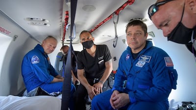 NASA astronauts Douglas Hurley (L) and Robert Behnken prepare to depart their helicopter at Naval Air Station Pensacola after the duo landed in their SpaceX Crew Dragon Endeavour spacecraft in the Gulf of Mexico off the coast of Pensacola, Florida, U.S. REUTERS