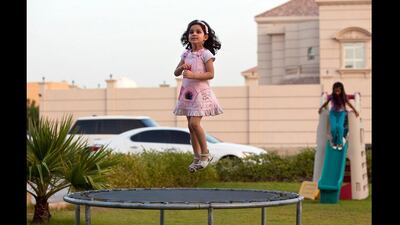 Three-year-old Judy al Enezi, jumps on a trampoline as she and her family play outside of their home in Khalifa City A neighborhood near Abu Dhabi. Silvia Razgova / The National