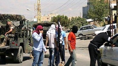 Lebanese Salafists inspect Syrian vehicles at a checkpoint in Majdal Anjar, as Lebanese soldiers look on.