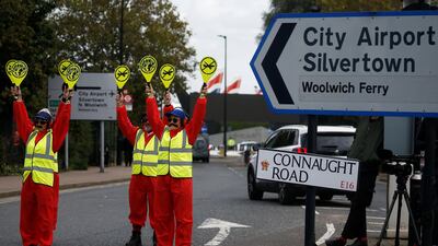 Extinction Rebellion protesters dressed as airport marshalls block the road during a demonstration, near London City Airport, in London, Britain, October 10, 2019. REUTERS/Henry Nicholls