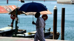 A man takes shade under an umbrella on sweltering day in Bur Dubai. Chris Whiteoak / The National