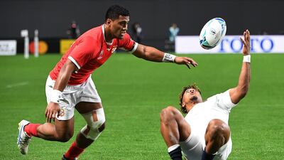 Tonga wing Viliami Lolohea, left, vies for the ball with England's wing Anthony Watson during the Pool C match at the Sapporo Dome. AFP