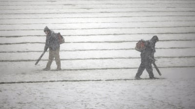 Workers use snowblowers to try to clear the field in Philadelphia on Sunday. Matt Rourke / AP