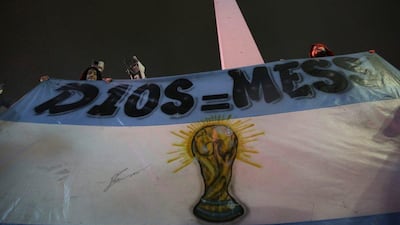 Lionel Messi fans hold a flag that reads in Spanish “Messi equals God”.