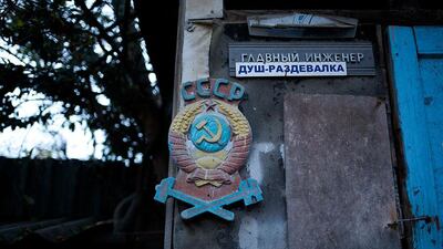 The emblem of the USSR hangs on the door of the outhouse in the yard of the railroad house in the village of Vesyoloye. Alexander Zemlianichenko / AP Photo
