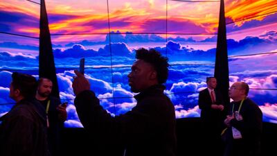 People walk through a display at CES. The new rollable LG OLED TV looks the same as the original LG OLED televisions AFP