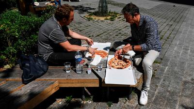 People eat outside after buying pizza for take away, in Paris, after France eased lockdown measures taken to curb the spread of the COVID-19. AFP