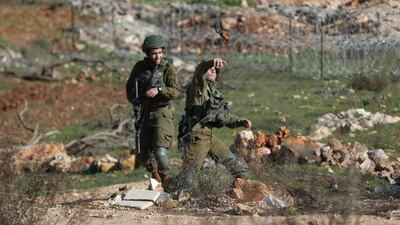 Israeli soldier hurls a sound grenade at Palestinians during clashes in the West Bank City of Ramallah, January 9, 2018. Alaa Badarneh / EPA