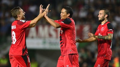 Sevilla's Carlos Bacca, centre, celebrates with Gerard Deulofeu, left, and Aleix Vidal, right, after a goal in their La Liga win against Elche on Sunday. Jose Jordan / AFP / October 19, 2014
