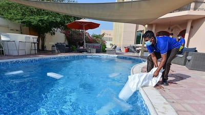 Employees of the Emirati company Gulf Ice Factory and Modern Ice Factory drop blocks of ice in a swimming pool in Dubai. AFP