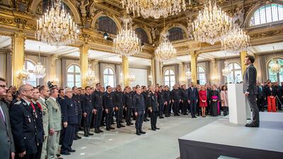 French President Emmanuel Macron stands at attention after addressing Paris Firefighters' brigade and security forces who took part at the fire extinguishing operations of the Notre Dame of Paris Cathedral fire, at the Elysee Palace in Paris, Thursday, April 18, 2019. France paid a daylong tribute Thursday to the Paris firefighters who saved the internationally revered Notre Dame Cathedral from collapse and rescued many of its treasures. AP