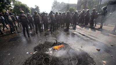 Indonesian anti riot police walk past burning tires during a protest following the announcement of the presidential election results in Jakarta, Indonesia, 22 May 2019. EPA