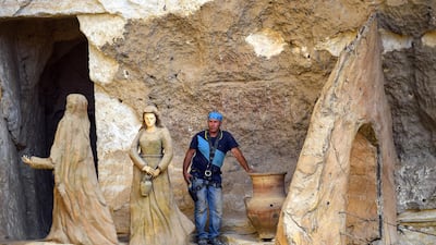 Polish artist Mario, sculptor of St. Simon the Tanner Monastery complex, poses for a picture alongside sculptures at the church in the Egyptian capital Cairo's eastern hillside Mokattam district. Mario spent more than two decades carving the rugged insides of the seven cave churches and chapels of the rock-hewn St. Simon Monastery and church complex atop Cairo's Mokattam hills, with designs inspired by biblical stories. It was all done to fulfil the wishes of the church's parish priest who met Mario in the early 1990s in Cairo. The Polish artist, who had arrived in Egypt earlier on an educational mission, was then looking for an opportunity to serve God at the monastery. AFP