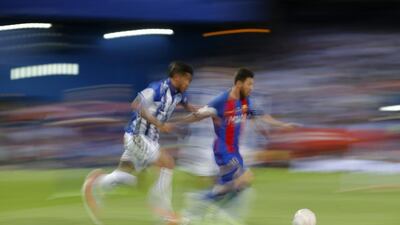 Barcelona’s Lionel Messi, right, is challenged by Alaves’ Theo Hernandez. Daniel Ochoa de Olza / AP Photo