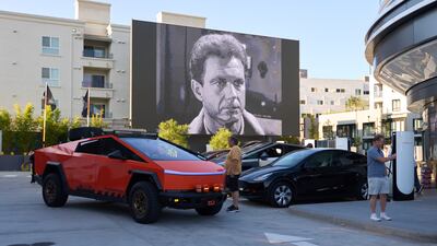 A movie plays on a large screen as drivers charge their cars at the Tesla Diner in Los Angeles. EPA