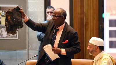 A survivor brandishes a piece of building debris at a council meeting about the Grenfell Tower disaster. REUTERS/Neil Hall