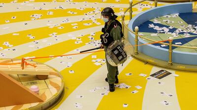 A police officer secures a cordon after police entered the Times Square shopping mall to search for protesters during a rally set against a new national security law in Hong Kong. AFP