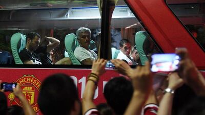 Manchester United manager Jose Mourinho (top C) looks at fans from the team bus after a training session a day before the 2016 International Champions Cup football match between Manchester City and Manchester United, in Beijing on July 24, 2016. Greg Baker / AFP