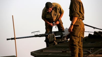 An Israeli soldier checks on a machine gun turret atop a Merkava battle tank stationed in the Israeli-annexed Golan Heights AFP