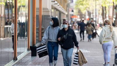 Shoppers wearing protective masks carry bags on Market Street in San Francisco, California. Bloomberg