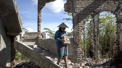 A woman works on the demolition site of a house in Sidoarjo. Ulet Ifansasti / Getty Images