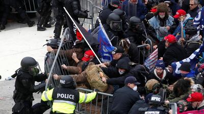 Pro-Trump protesters tear down a barricade as they clash with Capitol police during a rally to contest the certification of the 2020 US presidential election results by the US Congress. Reuters