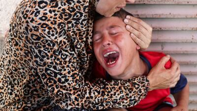 A Palestinian woman comforts a child as casualties from an Israeli strike arrive at Al Aqsa Martyrs Hospital in Deir Al Balah. Reuters