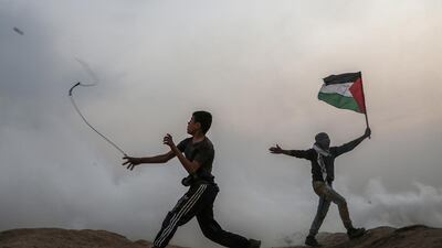 A Palestinian protester throws stones at Israeli troops during the clashes after Friday protests near the border between Israel and Gaza Strip in the east Gaza Strip, 30 November 2018. EPA
