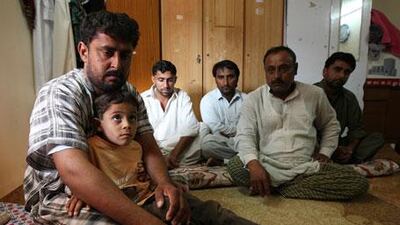 Mukhtiar Ahmed Khudabaksh, left, with his seven-year-old son Mustaffa and relatives at his home in Dubai.