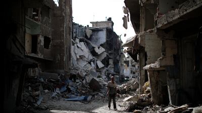 A man walks through rubble in the Palestinian refugee camp of Yarmouk in the Syrian capital Damascus, Syria, Saturday, Oct. 6, 2018. AP