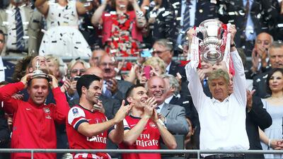 Wenger lifts the FA Cup in 2014 as Arsenal ended their nine-year trophy drought. Clive Mason / Getty Images