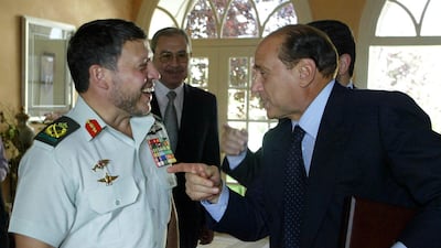 Jordan's King Abdullah II, left, laughs as he listens to Mr Berlusconi during their meeting at the royal palace in Amman, in June 2003. AFP