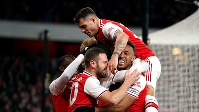 Arsenal's Nicolas Pepe, hidden, celebrates after scoring. PA