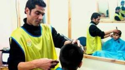 Hicham Mouchtak trims a young customer at his new shop in Selim 2, a state housing project in outer Casablanca.
