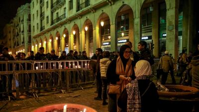 Lebanese anti-government protesters carry candles and national flags in Beirut. EPA