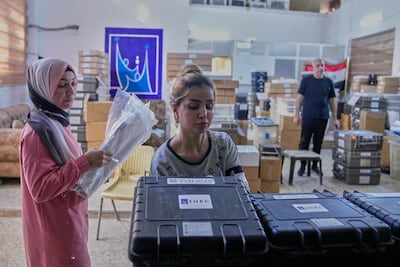 Workers prepare voting materials for Iraq's upcoming elections at a polling station in Baghdad. AP Photo