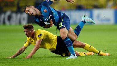 Borussia Dortmund defender Erik Durm, left, and Arsenal midfielder Jack Wilshere vie for the ball during their Champions League match on Tuesday night. Patrik Stollarz / AFP / September 16, 2014