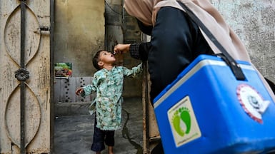 A health worker administers polio drops to a child in Karachi. AFP