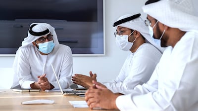 The group go over hand-sketched designs in Abu Dhabi. Victor Besa / The National