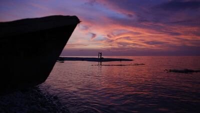 A man folds his fishing net for the night near where a dugout canoe lies on the beach in a seaside fishing neighborhood severally damaged by Hurricane Matthew, in Port Salut, Haiti. Rebecca Blackwell / AP