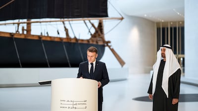 Emmanuel Macron signs the guestbook at the Zayed National Museum alongside President Sheikh Mohamed. Abdulla Al Bedwawi / UAE Presidential Court