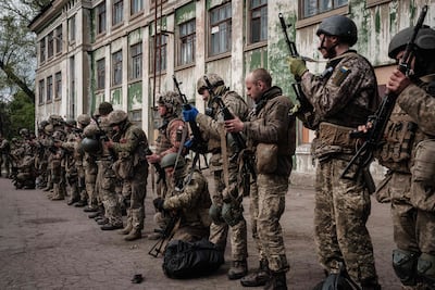 Ukrainian soldiers unload their guns as they arrive at an abandoned building to rest and receive medical treatment after fighting on the front line for two months near Kramatorsk, eastern Ukraine. AFP