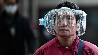 A woman wears a plastic water bottle with a cutout to cover her face, as she walks on a footbridge in Hong Kong on January 31, 2020, as a preventative measure following a virus outbreak which began in the Chinese city of Wuhan. AFP