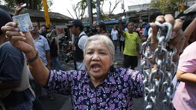 A voter holds the chains that held the gate of the polling station closed, demanding the right to vote in Bangkok. The national focus was riveted on the capital where 488 of the city’s 6,600 polling stations were shut and several skirmishes broke out between protesters intent on disrupting the vote and frustrated would-be voters. AP Photo